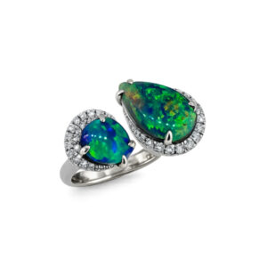 This handcrafted Australian black opal ring features two vibrant natural black opals with brilliant green play of colour, elegantly showcased in a contemporary crossover design. Crafted in 18k gold, this striking two-stone ring celebrates the individuality of Australian black opals while offering a modern, sculptural style. A one-of-a-kind statement piece for collectors of fine Australian opal jewellery.